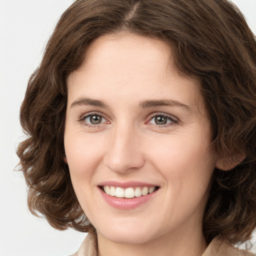 Joyful white young-adult female with medium  brown hair and green eyes