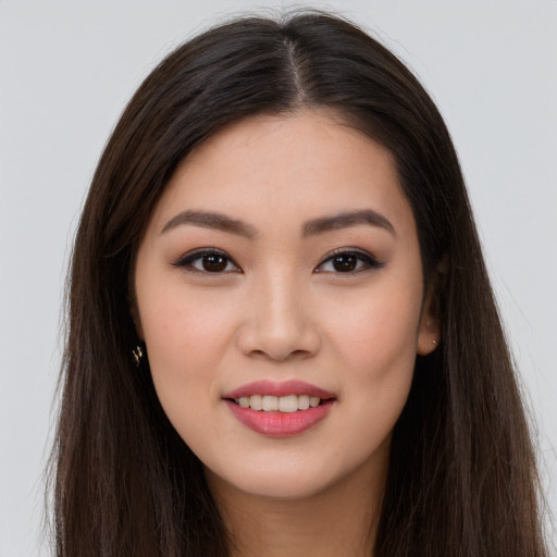 Joyful asian young-adult female with long  brown hair and brown eyes