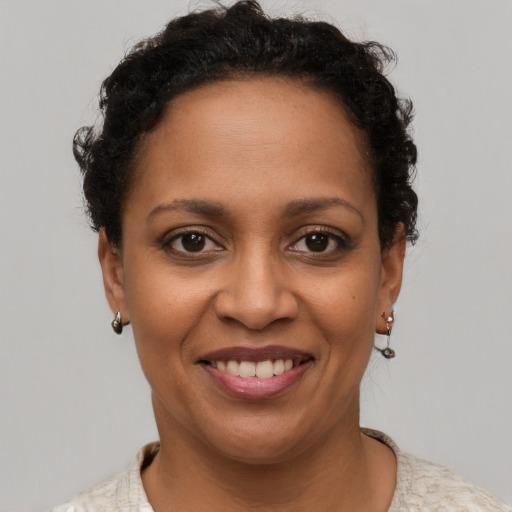 Joyful black young-adult female with short  brown hair and brown eyes