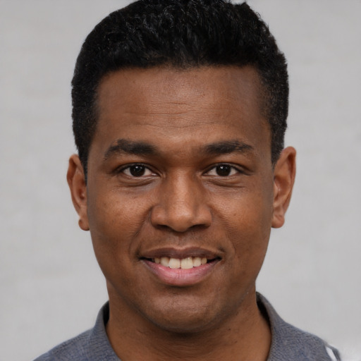 Joyful black young-adult male with short  black hair and brown eyes