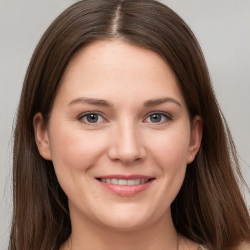 Joyful white young-adult female with long  brown hair and grey eyes