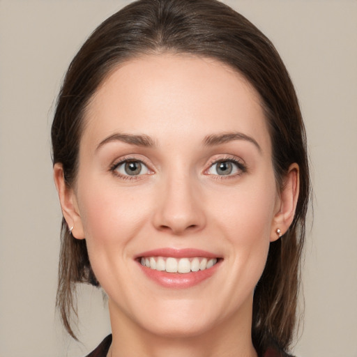 Joyful white young-adult female with medium  brown hair and grey eyes