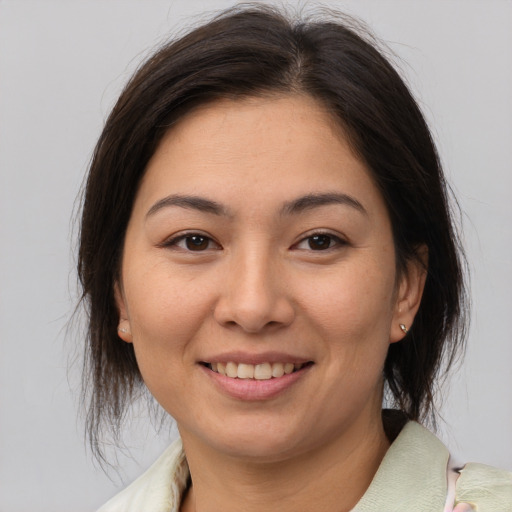 Joyful white young-adult female with medium  brown hair and brown eyes