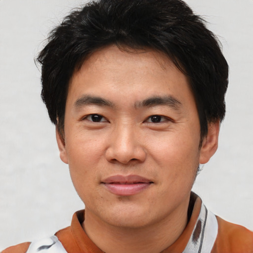 Joyful asian young-adult male with short  brown hair and brown eyes
