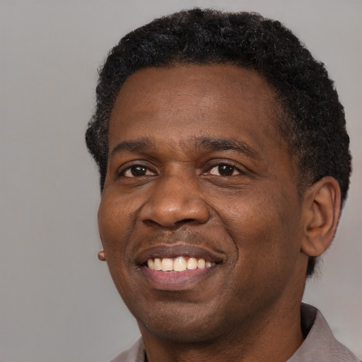 Joyful black adult male with short  brown hair and brown eyes