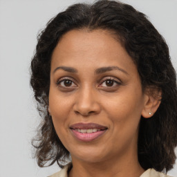 Joyful latino adult female with medium  brown hair and brown eyes