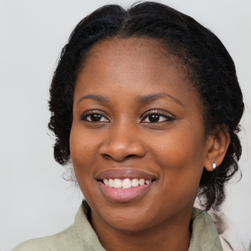 Joyful black young-adult female with long  brown hair and brown eyes