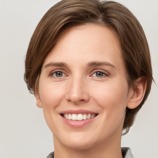 Joyful white young-adult female with short  brown hair and grey eyes