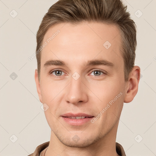 Joyful white young-adult male with short  brown hair and grey eyes