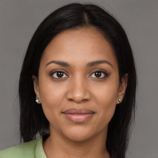 Joyful black young-adult female with long  black hair and brown eyes
