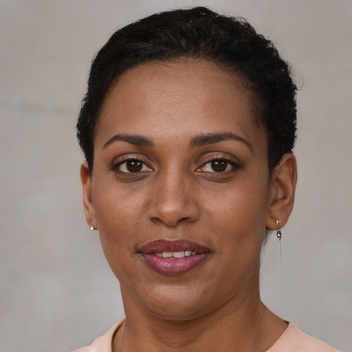Joyful black young-adult female with short  brown hair and brown eyes