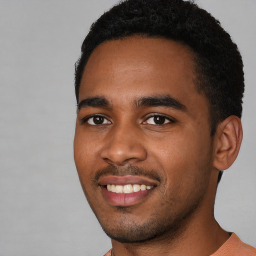 Joyful black young-adult male with short  black hair and brown eyes