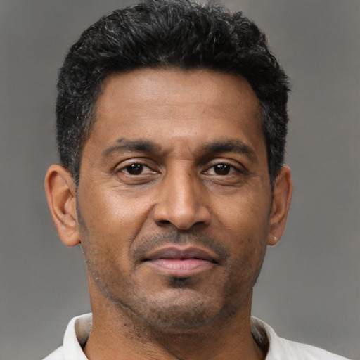 Joyful latino adult male with short  black hair and brown eyes