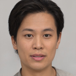 Joyful asian young-adult male with short  brown hair and brown eyes