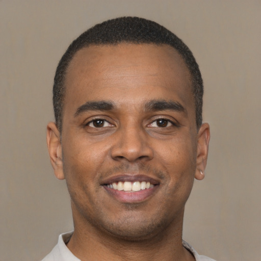 Joyful latino young-adult male with short  brown hair and brown eyes