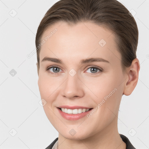 Joyful white young-adult female with medium  brown hair and grey eyes