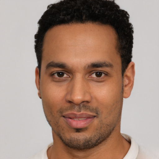 Joyful black young-adult male with short  black hair and brown eyes