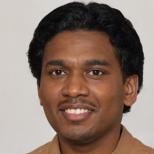 Joyful black young-adult male with short  black hair and brown eyes