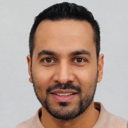 Joyful latino young-adult male with short  black hair and brown eyes