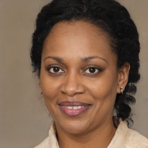 Joyful black adult female with medium  brown hair and brown eyes