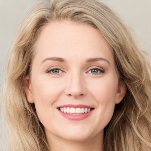 Joyful white young-adult female with long  brown hair and blue eyes