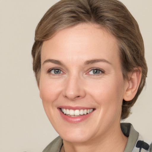 Joyful white young-adult female with medium  brown hair and grey eyes