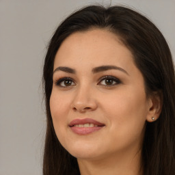 Joyful white young-adult female with long  brown hair and brown eyes