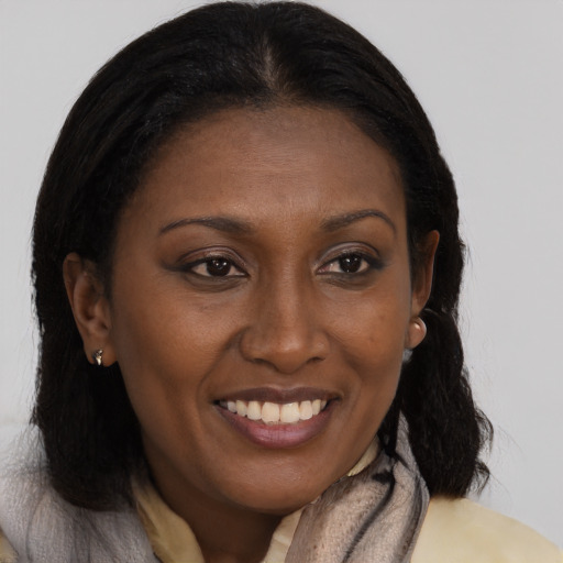 Joyful black adult female with long  brown hair and brown eyes