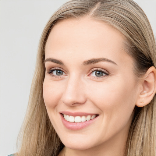 Joyful white young-adult female with long  brown hair and blue eyes