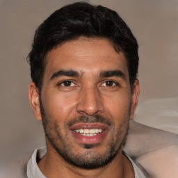 Joyful latino young-adult male with short  brown hair and brown eyes