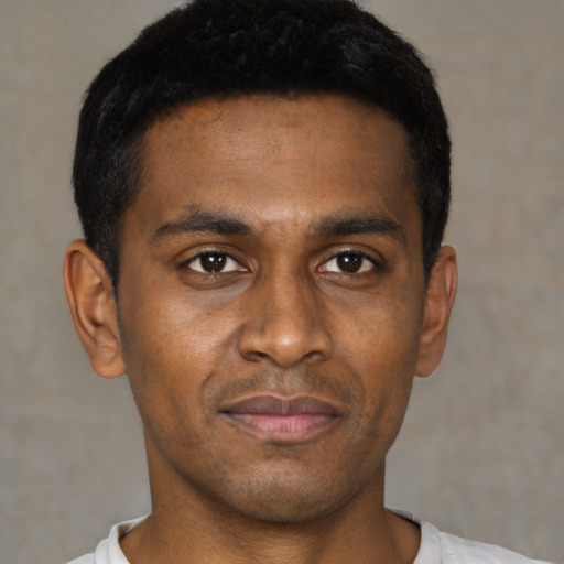 Joyful black young-adult male with short  black hair and brown eyes