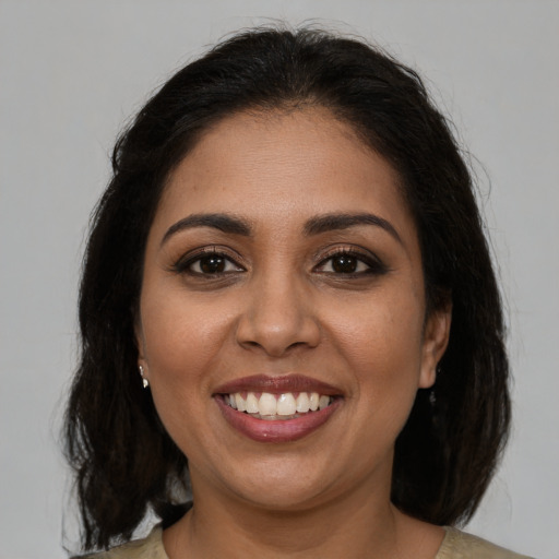 Joyful latino young-adult female with medium  brown hair and brown eyes