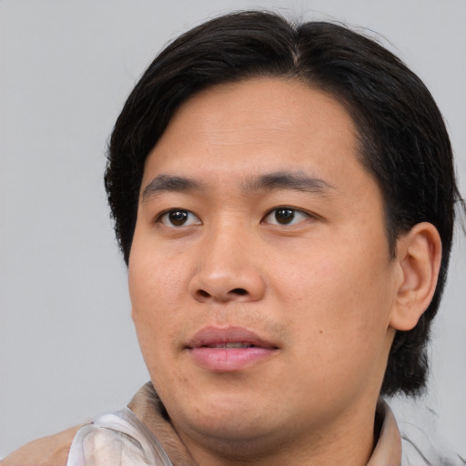 Joyful asian young-adult male with medium  black hair and brown eyes