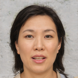 Joyful asian adult female with medium  brown hair and brown eyes