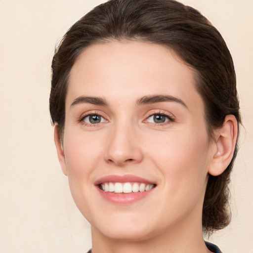 Joyful white young-adult female with medium  brown hair and green eyes