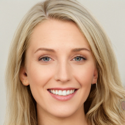 Joyful white young-adult female with long  brown hair and blue eyes