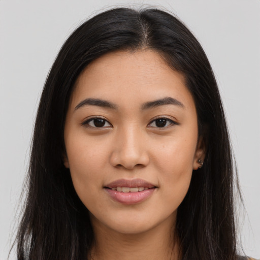 Joyful latino young-adult female with long  brown hair and brown eyes