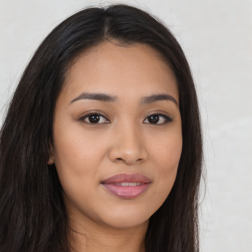 Joyful latino young-adult female with long  brown hair and brown eyes