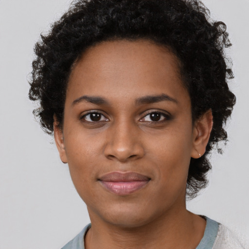 Joyful black young-adult female with short  black hair and brown eyes