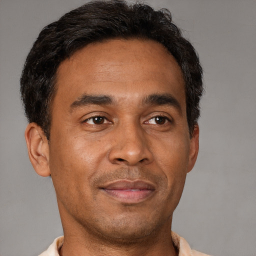 Joyful latino adult male with short  brown hair and brown eyes