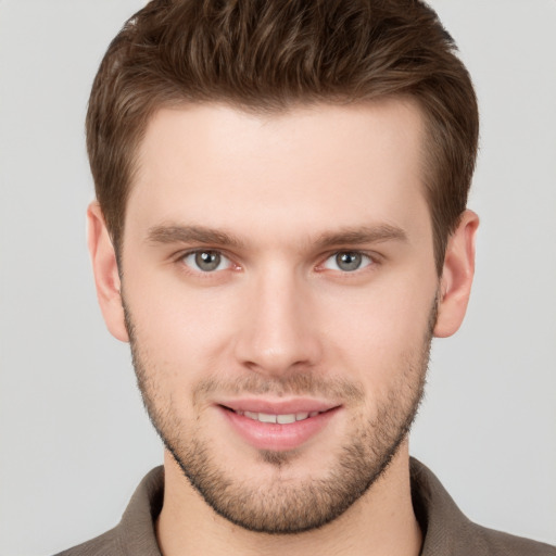 Joyful white young-adult male with short  brown hair and grey eyes