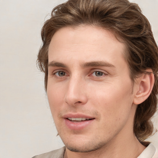 Joyful white young-adult male with medium  brown hair and grey eyes