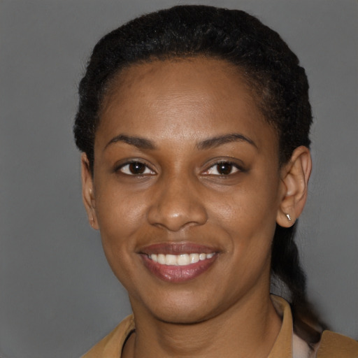 Joyful black young-adult female with short  black hair and brown eyes
