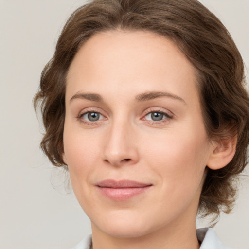 Joyful white young-adult female with medium  brown hair and green eyes