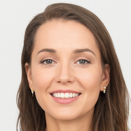 Joyful white young-adult female with long  brown hair and grey eyes