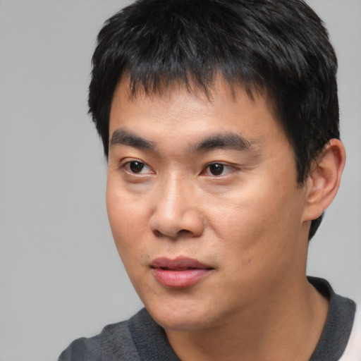 Joyful asian young-adult male with short  black hair and brown eyes