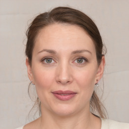 Joyful white young-adult female with medium  brown hair and grey eyes