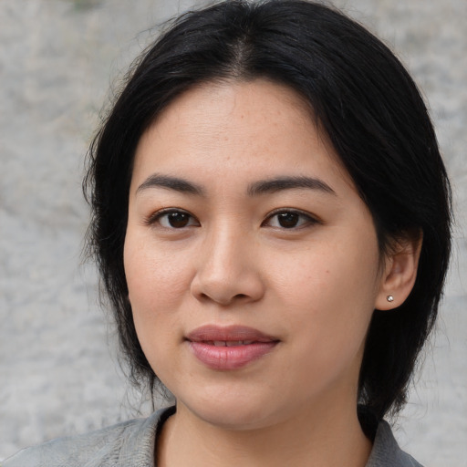 Joyful asian young-adult female with medium  black hair and brown eyes