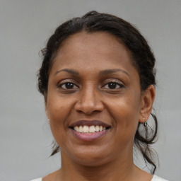 Joyful black adult female with medium  brown hair and brown eyes