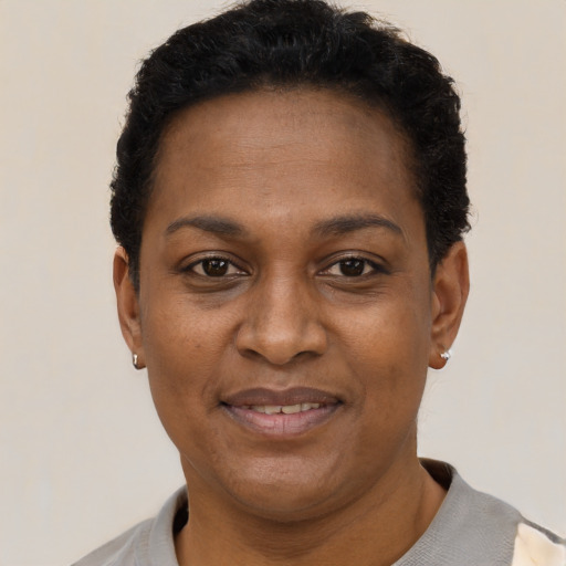 Joyful black adult female with short  black hair and brown eyes